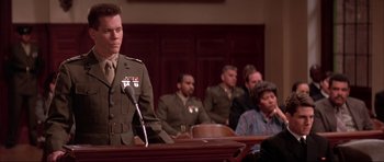 Movie still from “A Few Good Men” (1992), directed by Rob Reiner – A man in a military uniform standing in front of a group of people; Medium shot, Low angle