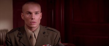 Movie still from “A Few Good Men” (1992), directed by Rob Reiner – A man in a military uniform sitting in front of a wooden wall; Close Up shot, Low angle