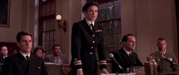 Movie still from “A Few Good Men” (1992), directed by Rob Reiner – A woman in a uniform stands at a podium; Medium shot, Low angle