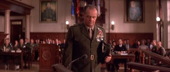 Movie still from “A Few Good Men” (1992), directed by Rob Reiner – A man in a military uniform standing in front of a microphone; Medium shot, Low angle