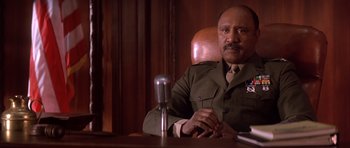 Movie still from “A Few Good Men” (1992), directed by Rob Reiner – A man in a uniform sitting in front of a microphone; Close Up shot, Low angle