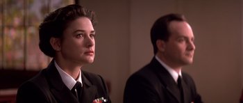 Movie still from “A Few Good Men” (1992), directed by Rob Reiner – A man and a woman in suits looking at something; Close Up shot, Low angle