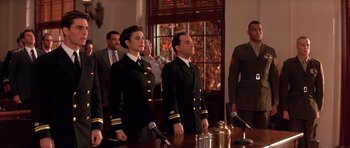 Movie still from “A Few Good Men” (1992), directed by Rob Reiner – A group of people standing in front of a wooden table with microphones; Medium shot, Low angle