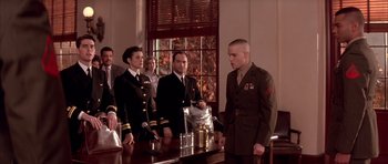 Movie still from “A Few Good Men” (1992), directed by Rob Reiner – A group of men standing around a table in front of a window; Medium shot, Low angle