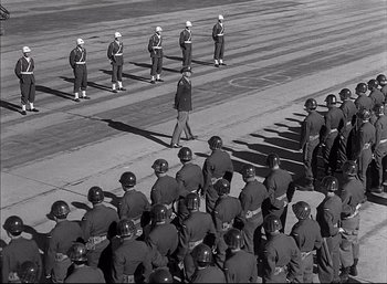 Movie still from “A Foreign Affair” (1948), directed by Billy Wilder – A black and white photo of a line of men in uniform; Wide shot, High angle