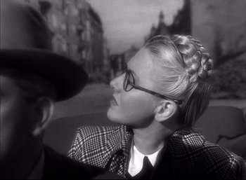 Movie still from “A Foreign Affair” (1948), directed by Billy Wilder – A man and a woman are sitting on a street; Close Up shot, Over the shoulder angle