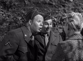 Movie still from “A Foreign Affair” (1948), directed by Billy Wilder – A couple of men standing next to each other; Medium shot, Over the shoulder angle