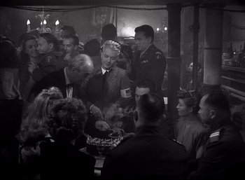 Movie still from “A Foreign Affair” (1948), directed by Billy Wilder – A group of people gathered around a table; Medium shot, High angle