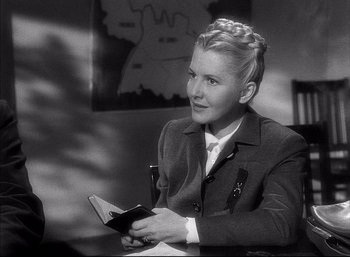Movie still from “A Foreign Affair” (1948), directed by Billy Wilder – A young woman holding a wallet while sitting in a chair; Close Up shot, Over the shoulder angle
