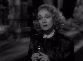 Movie still from “A Foreign Affair” (1948), directed by Billy Wilder – An old photo of a woman holding a microphone; Close Up shot, Over the shoulder angle