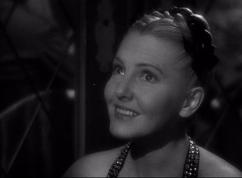 Movie still from “A Foreign Affair” (1948), directed by Billy Wilder – A black and white photo of a woman smiling; Close Up shot, Over the shoulder angle