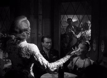 Movie still from “A Foreign Affair” (1948), directed by Billy Wilder – A man and a woman are sitting at a table; Medium shot, Over the shoulder angle