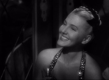 Movie still from “A Foreign Affair” (1948), directed by Billy Wilder – A black and white photo of a woman smiling; Close Up shot, Over the shoulder angle