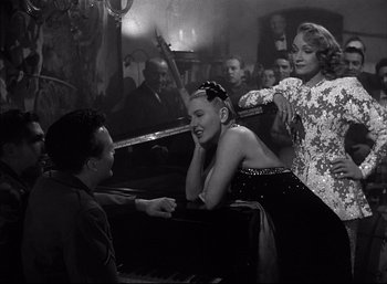 Movie still from “A Foreign Affair” (1948), directed by Billy Wilder – A man and two women sitting in front of a grand piano; Medium shot, High angle