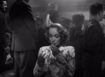 Movie still from “A Foreign Affair” (1948), directed by Billy Wilder – A black - and - white photo of a woman smoking a cigarette; Medium shot, Over the shoulder angle