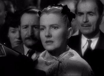 Movie still from “A Foreign Affair” (1948), directed by Billy Wilder – A black and white photo of a woman in front of a group of men; Close Up shot, Low angle