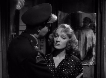 Movie still from “A Foreign Affair” (1948), directed by Billy Wilder – A woman in a polka dot dress and a man in a military uniform; Close Up shot, Over the shoulder angle
