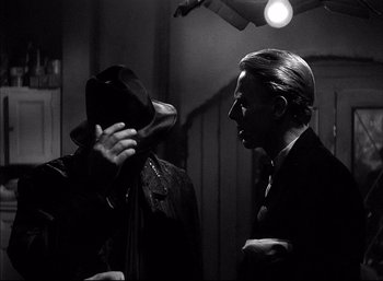 Movie still from “A Foreign Affair” (1948), directed by Billy Wilder – A man in a hat and a man in a suit and tie; Close Up shot, Over the shoulder angle