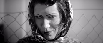 Movie still from “A Girl Walks Home Alone at Night” (2014), directed by Ana Lily Amirpour – A black and white photo of a woman wearing a head scarf; Close Up shot, Low angle