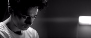 Movie still from “A Girl Walks Home Alone at Night” (2014), directed by Ana Lily Amirpour – A black and white photo of a man's face; Close Up shot, Low angle