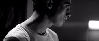 Movie still from “A Girl Walks Home Alone at Night” (2014), directed by Ana Lily Amirpour – A man's face in black - and - white; Close Up shot, Low angle