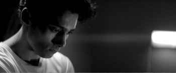 Movie still from “A Girl Walks Home Alone at Night” (2014), directed by Ana Lily Amirpour – A black and white photo of a man looking down; Close Up shot, Low angle