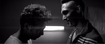 Movie still from “A Girl Walks Home Alone at Night” (2014), directed by Ana Lily Amirpour – Two men face each other in a room; Close Up shot, Low angle