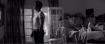 Movie still from “A Girl Walks Home Alone at Night” (2014), directed by Ana Lily Amirpour – A man standing in front of a living room door; Medium shot, Low angle