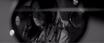Movie still from “A Girl Walks Home Alone at Night” (2014), directed by Ana Lily Amirpour – A black and white photo of a woman with a polka dot scarf; Close Up shot, Low angle