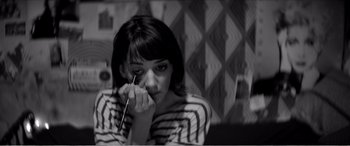 Movie still from “A Girl Walks Home Alone at Night” (2014), directed by Ana Lily Amirpour – A black - and - white photo of a woman holding a pencil; Close Up shot, High angle
