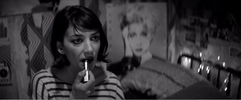 Movie still from “A Girl Walks Home Alone at Night” (2014), directed by Ana Lily Amirpour – A black - and - white photo of a woman holding a lipstick; Close Up shot, Over the shoulder angle