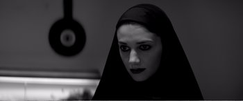 Movie still from “A Girl Walks Home Alone at Night” (2014), directed by Ana Lily Amirpour – A woman with a black veil on her head; Close Up shot, Low angle