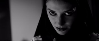 Movie still from “A Girl Walks Home Alone at Night” (2014), directed by Ana Lily Amirpour – A woman's face in black and white; Close Up shot, Low angle