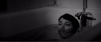 Movie still from “A Girl Walks Home Alone at Night” (2014), directed by Ana Lily Amirpour – A woman in a bathtub with her head above the water; Close Up shot, High angle