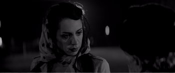 Movie still from “A Girl Walks Home Alone at Night” (2014), directed by Ana Lily Amirpour – A black and white photo of a woman with a veil; Close Up shot, Over the shoulder angle