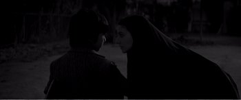 Movie still from “A Girl Walks Home Alone at Night” (2014), directed by Ana Lily Amirpour – Two people standing next to each other on a field at night; Close Up shot, Over the shoulder angle