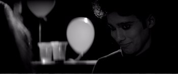 Movie still from “A Girl Walks Home Alone at Night” (2014), directed by Ana Lily Amirpour – A man sitting in front of a mirror in a dark room; Close Up shot, Over the shoulder angle