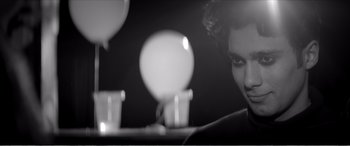 Movie still from “A Girl Walks Home Alone at Night” (2014), directed by Ana Lily Amirpour – A woman sitting in front of a table with candles; Close Up shot, Over the shoulder angle
