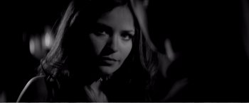 Movie still from “A Girl Walks Home Alone at Night” (2014), directed by Ana Lily Amirpour – A black - and - white photo of a woman in a dark room; Close Up shot, Over the shoulder angle