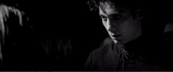 Movie still from “A Girl Walks Home Alone at Night” (2014), directed by Ana Lily Amirpour – A young man is looking down at his face; Close Up shot, Low angle