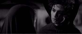 Movie still from “A Girl Walks Home Alone at Night” (2014), directed by Ana Lily Amirpour – A young man with a hooded jacket looking at the camera; Close Up shot, Over the shoulder angle