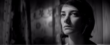 Movie still from “A Girl Walks Home Alone at Night” (2014), directed by Ana Lily Amirpour – A black - and - white photo of a young woman looking into the distance; Close Up shot, Low angle