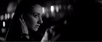 Movie still from “A Girl Walks Home Alone at Night” (2014), directed by Ana Lily Amirpour – A black - and - white photo of a woman looking at the camera; Close Up shot, Low angle