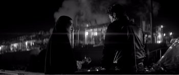 Movie still from “A Girl Walks Home Alone at Night” (2014), directed by Ana Lily Amirpour – A man and a woman sitting at a table; Medium shot, Over the shoulder angle