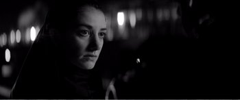 Movie still from “A Girl Walks Home Alone at Night” (2014), directed by Ana Lily Amirpour – A black - and - white photo of a woman in the dark; Close Up shot, Over the shoulder angle