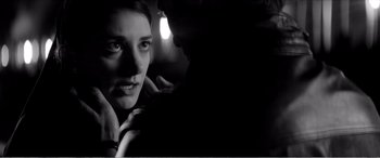 Movie still from “A Girl Walks Home Alone at Night” (2014), directed by Ana Lily Amirpour – A black - and - white photo of a woman in a dark room; Close Up shot, Over the shoulder angle