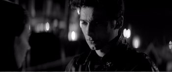 Movie still from “A Girl Walks Home Alone at Night” (2014), directed by Ana Lily Amirpour – A young man is looking at the camera; Close Up shot, Low angle