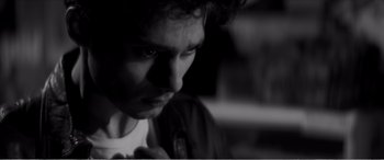 Movie still from “A Girl Walks Home Alone at Night” (2014), directed by Ana Lily Amirpour – A black - and - white photo of a man looking down; Close Up shot, Low angle