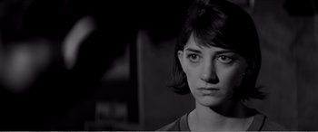 Movie still from “A Girl Walks Home Alone at Night” (2014), directed by Ana Lily Amirpour – A black - and - white photo of a woman with short hair; Close Up shot, Low angle