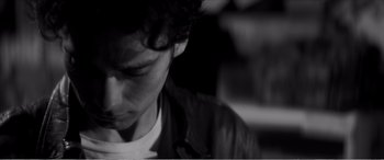 Movie still from “A Girl Walks Home Alone at Night” (2014), directed by Ana Lily Amirpour – A young man is looking down at his face; Close Up shot, Low angle